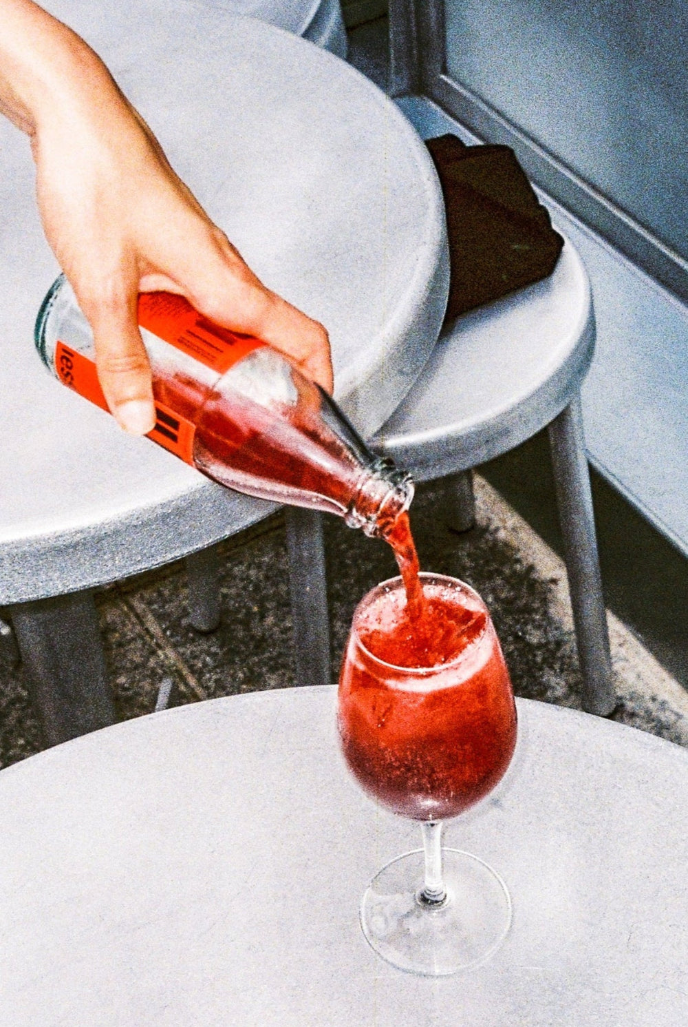 Serving IESSI Il Frizzante, alcohol-free spritz, in a glass with ice cubes.